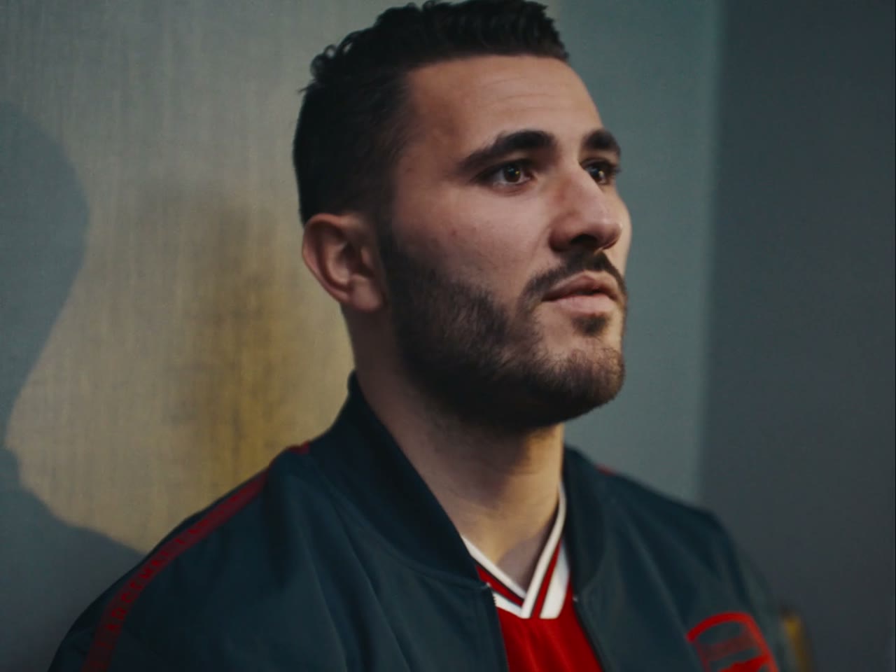 Still from Adidas x Arsenal 'This Is Home': portrait of an Arsenal footballer against a dark backdrop